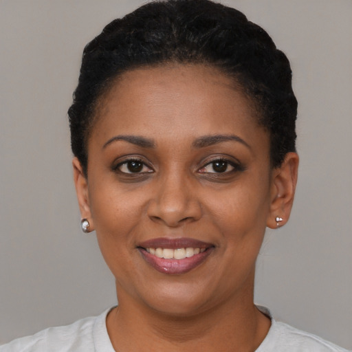 Joyful black young-adult female with short  black hair and brown eyes