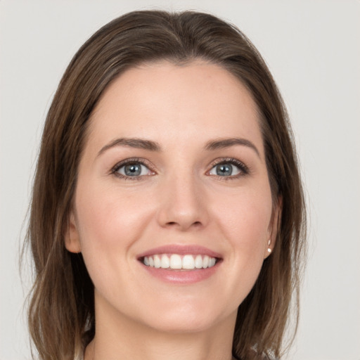 Joyful white young-adult female with medium  brown hair and grey eyes