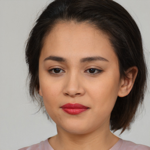 Joyful asian young-adult female with medium  brown hair and brown eyes