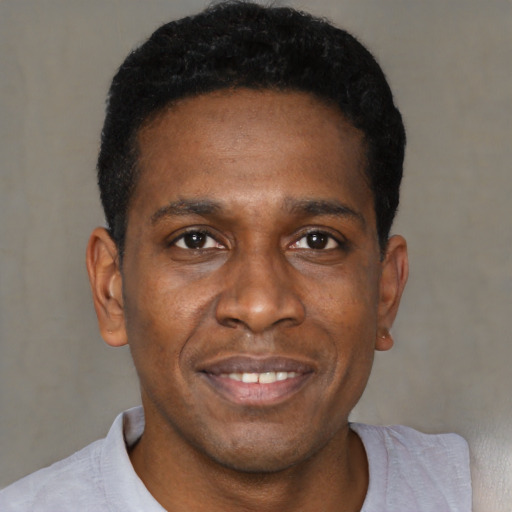 Joyful black young-adult male with short  black hair and brown eyes