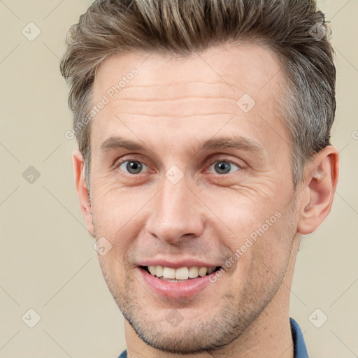 Joyful white adult male with short  brown hair and brown eyes