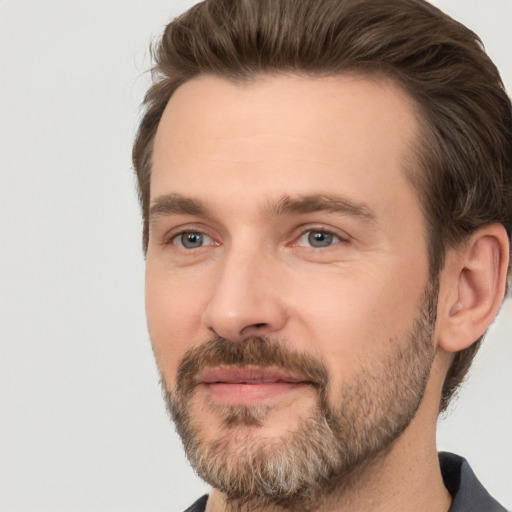 Joyful white adult male with short  brown hair and brown eyes