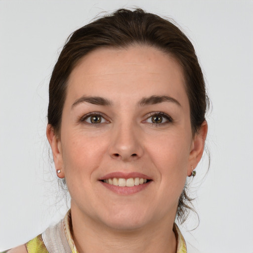 Joyful white young-adult female with medium  brown hair and grey eyes