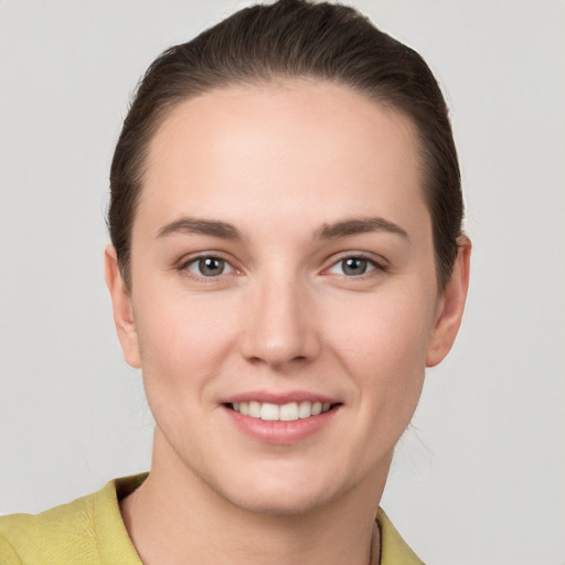 Joyful white young-adult female with short  brown hair and grey eyes