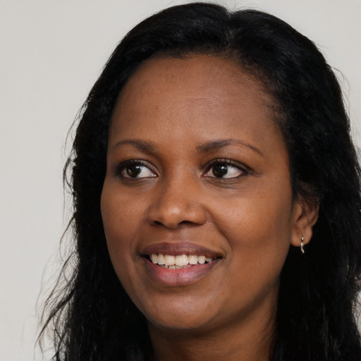 Joyful black young-adult female with long  black hair and brown eyes
