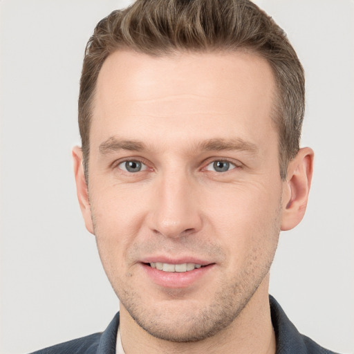 Joyful white young-adult male with short  brown hair and grey eyes