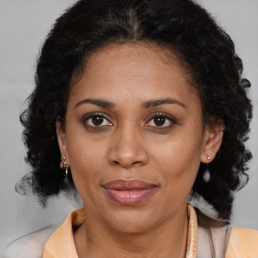 Joyful latino adult female with medium  brown hair and brown eyes