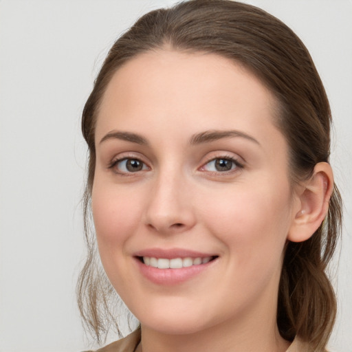 Joyful white young-adult female with medium  brown hair and grey eyes