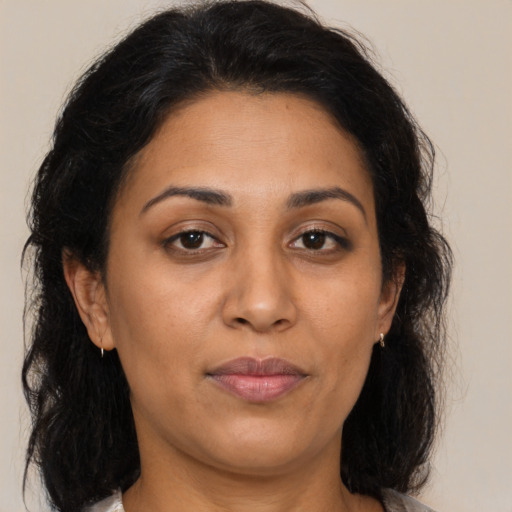 Joyful latino adult female with medium  brown hair and brown eyes