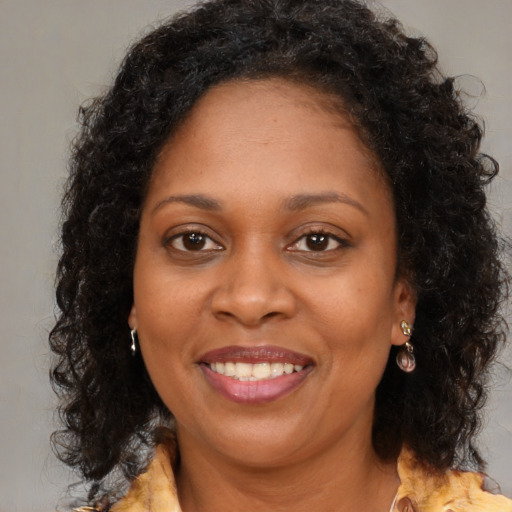 Joyful black adult female with long  brown hair and brown eyes