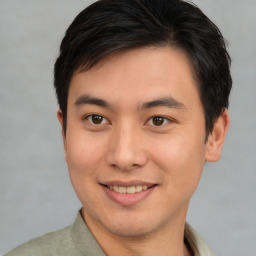 Joyful asian young-adult male with short  brown hair and brown eyes