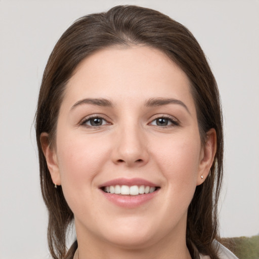 Joyful white young-adult female with medium  brown hair and grey eyes