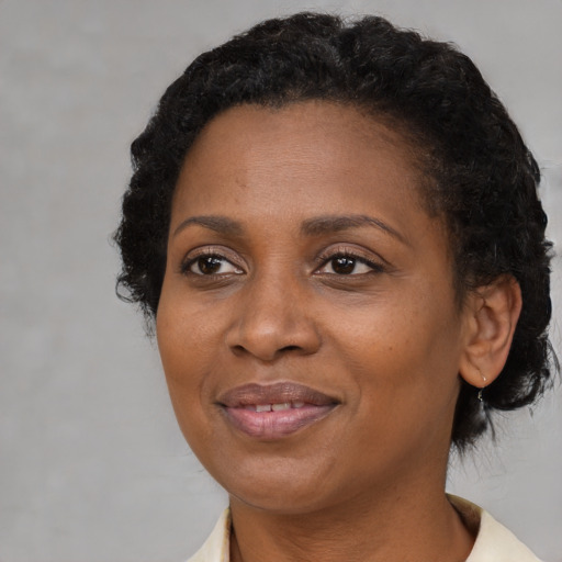 Joyful black adult female with short  brown hair and brown eyes