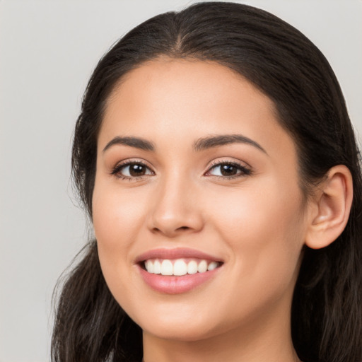 Joyful latino young-adult female with long  brown hair and brown eyes