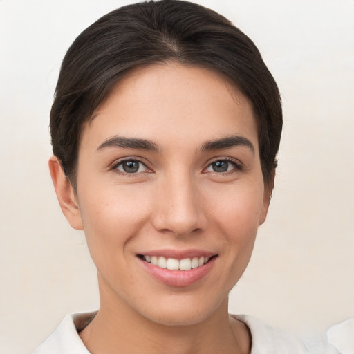 Joyful white young-adult female with short  brown hair and brown eyes