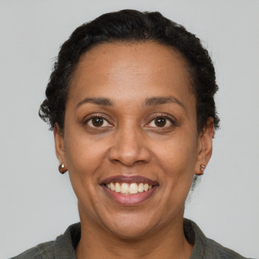 Joyful black adult female with short  brown hair and brown eyes