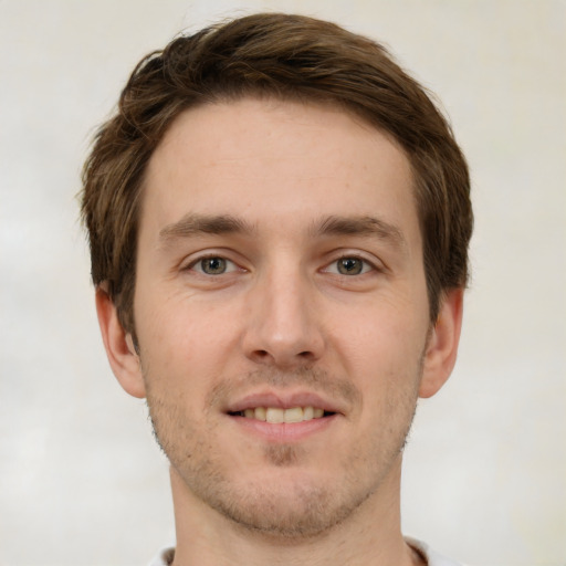 Joyful white young-adult male with short  brown hair and green eyes