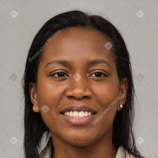 Joyful black young-adult female with long  brown hair and brown eyes