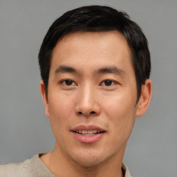 Joyful asian young-adult male with short  brown hair and brown eyes