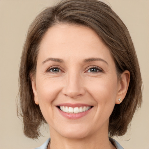 Joyful white young-adult female with medium  brown hair and green eyes