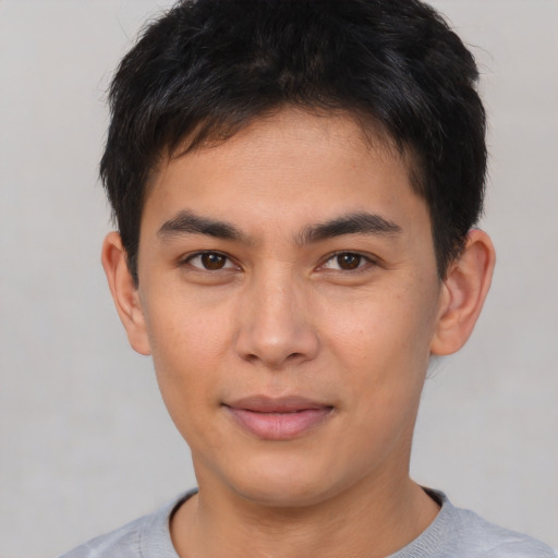 Joyful asian young-adult male with short  brown hair and brown eyes