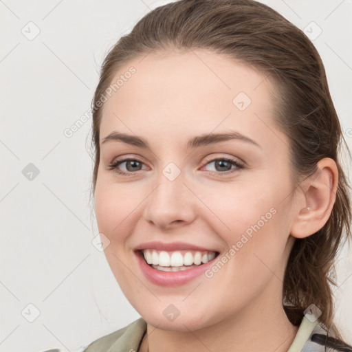 Joyful white young-adult female with medium  brown hair and grey eyes