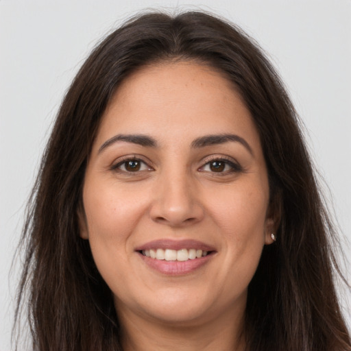 Joyful white young-adult female with long  brown hair and brown eyes