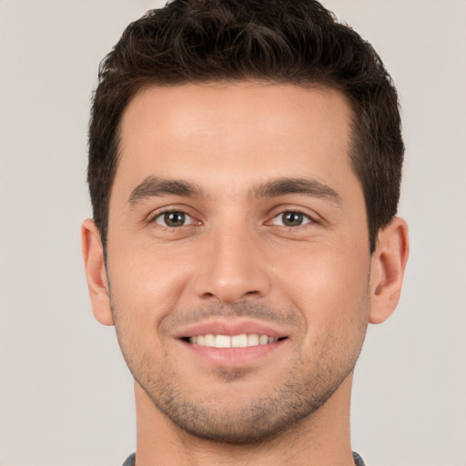 Joyful white young-adult male with short  brown hair and brown eyes