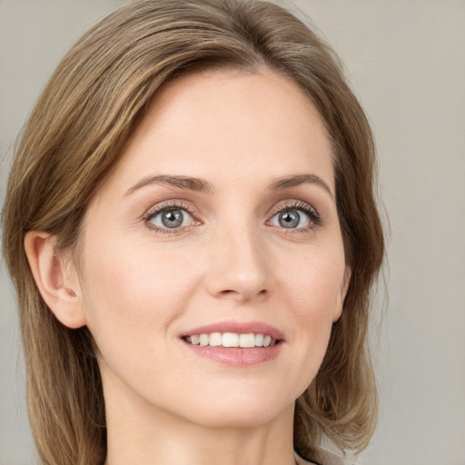 Joyful white young-adult female with medium  brown hair and green eyes