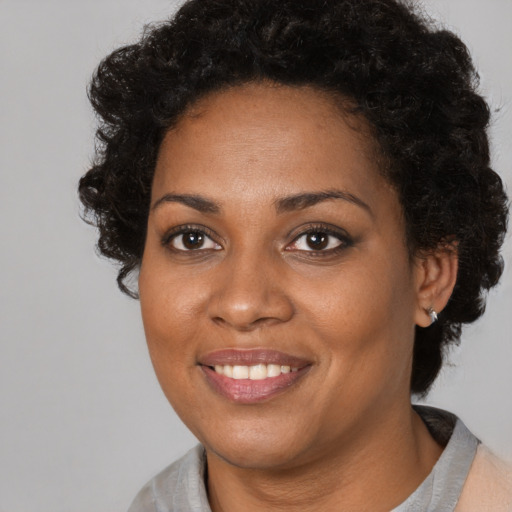 Joyful black adult female with medium  black hair and brown eyes