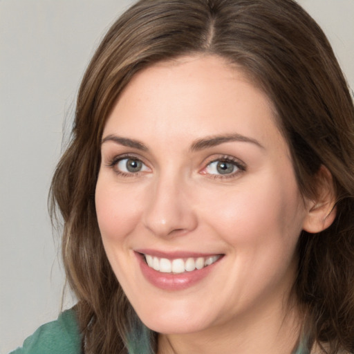 Joyful white young-adult female with medium  brown hair and green eyes