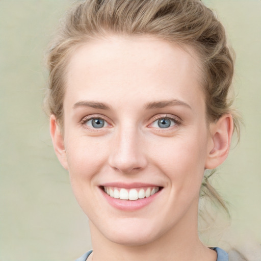 Joyful white young-adult female with medium  brown hair and blue eyes