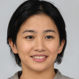 Joyful asian young-adult female with medium  brown hair and brown eyes