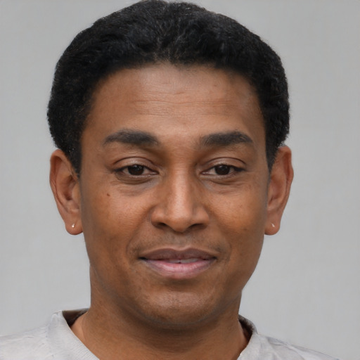 Joyful black adult male with short  black hair and brown eyes