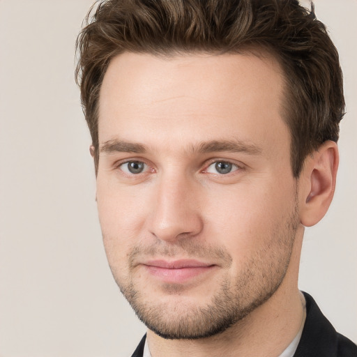 Joyful white young-adult male with short  brown hair and grey eyes