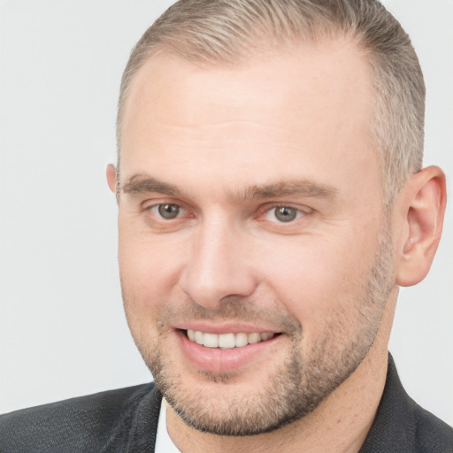 Joyful white adult male with short  brown hair and grey eyes