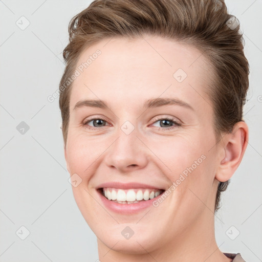 Joyful white young-adult female with short  brown hair and grey eyes