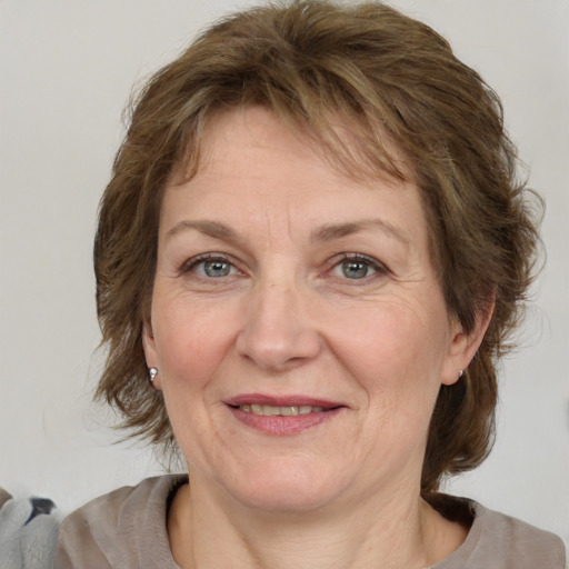 Joyful white adult female with medium  brown hair and grey eyes