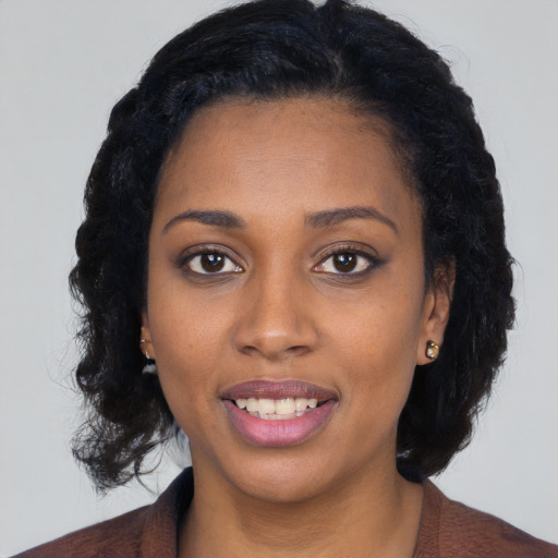 Joyful black young-adult female with long  black hair and brown eyes