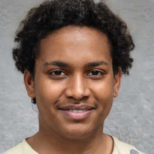 Joyful black young-adult male with short  brown hair and brown eyes