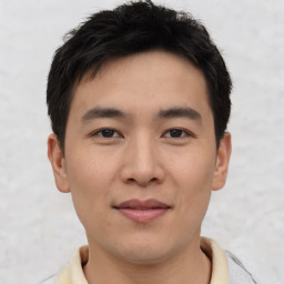 Joyful asian young-adult male with short  black hair and brown eyes