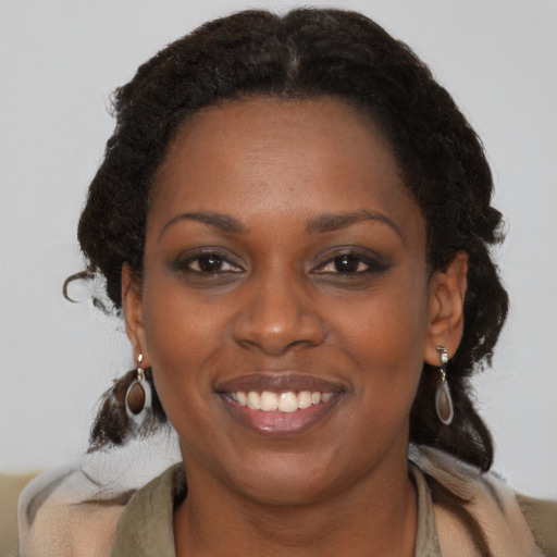 Joyful black young-adult female with medium  brown hair and brown eyes