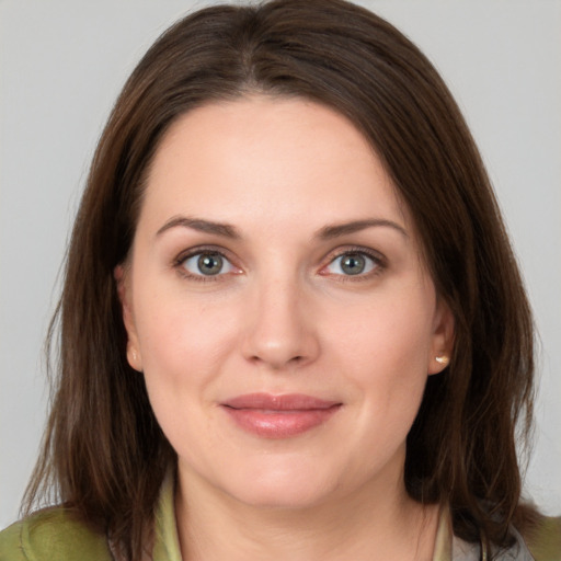 Joyful white young-adult female with medium  brown hair and grey eyes