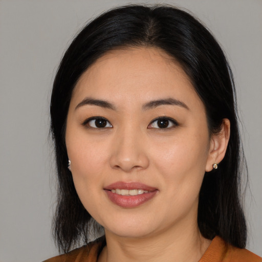 Joyful asian young-adult female with long  brown hair and brown eyes