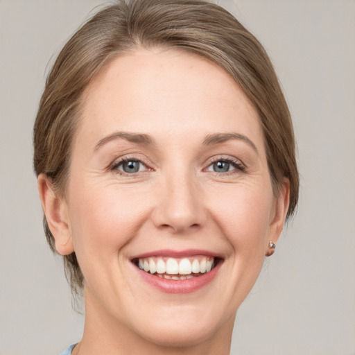 Joyful white adult female with medium  brown hair and grey eyes