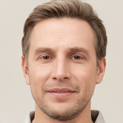 Joyful white adult male with short  brown hair and grey eyes