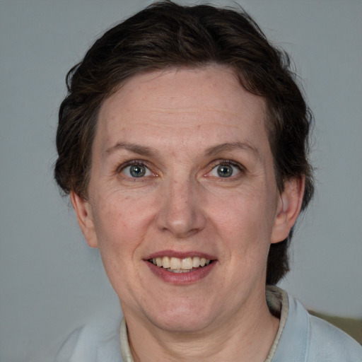 Joyful white adult female with short  brown hair and blue eyes