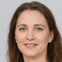 Joyful white adult female with long  brown hair and grey eyes