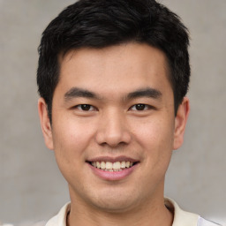 Joyful asian young-adult male with short  brown hair and brown eyes