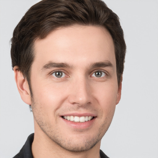 Joyful white young-adult male with short  brown hair and grey eyes